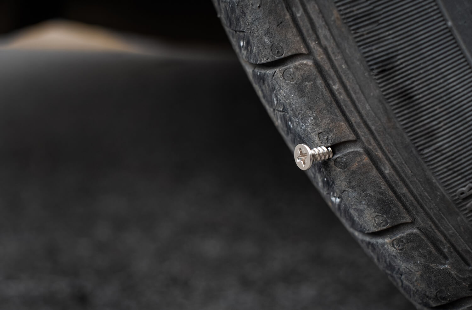 Pneu de voiture avec clou planté dedans crevaison vandalisme ou accident