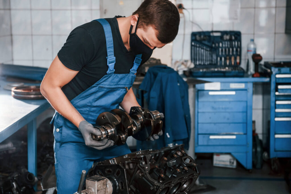 garagiste qui répare un moteur