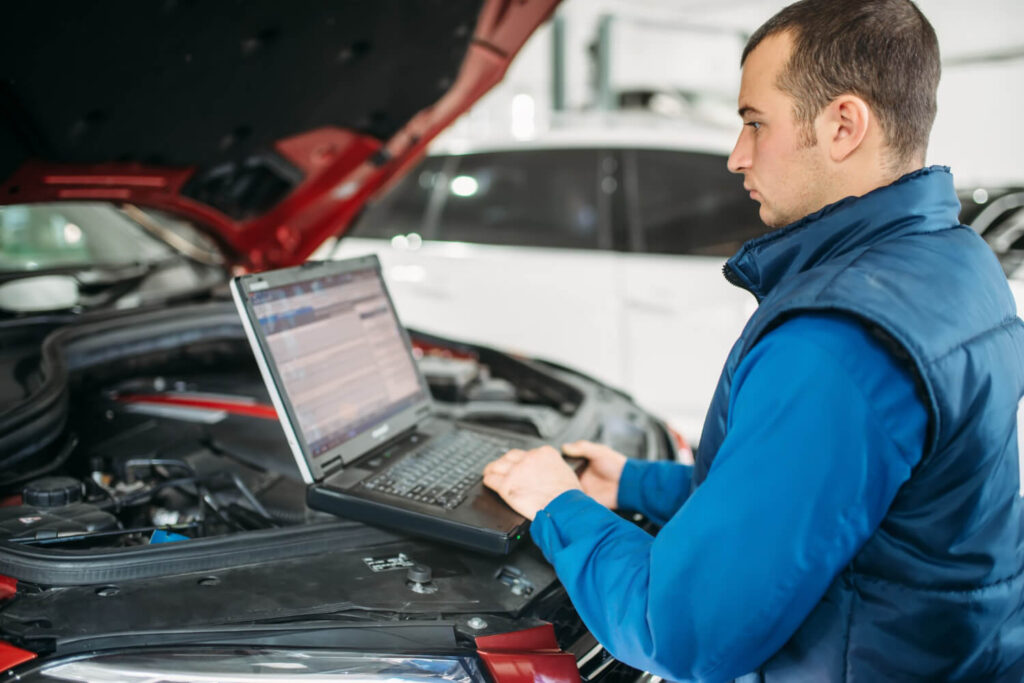Mécanicien diagnostiquant perte de puissance sur moteur diesel Peugeot 208 avec valise OBD