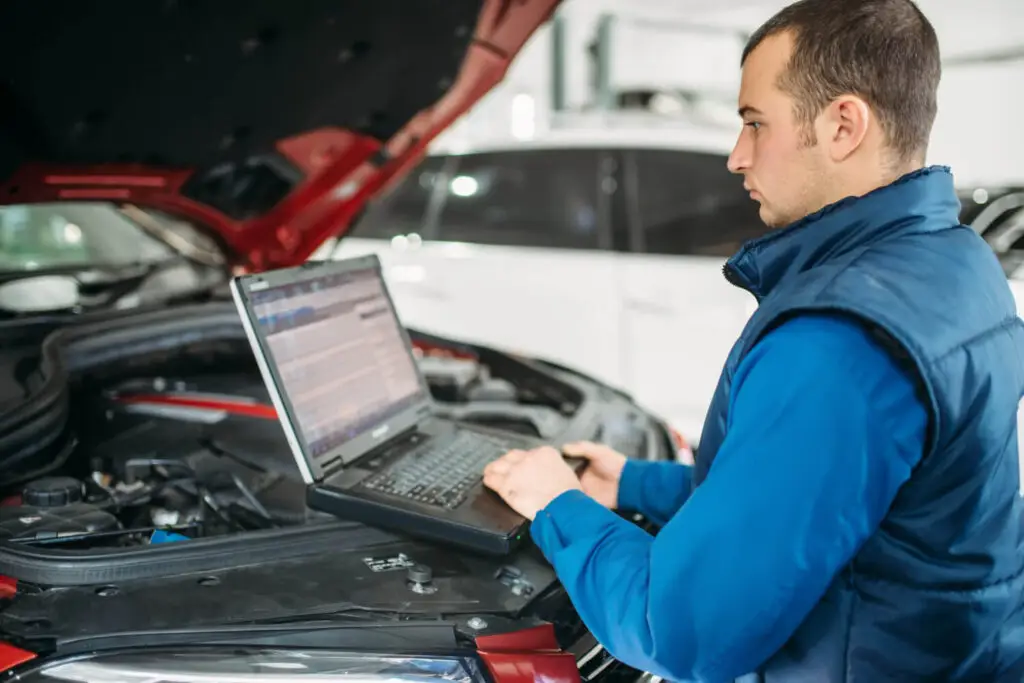 Mécanicien diagnostiquant perte de puissance sur moteur diesel Peugeot 208 avec valise OBD