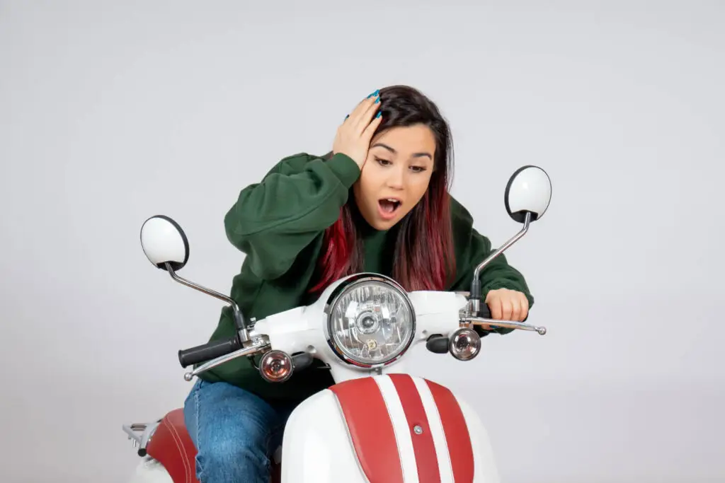 femme désespéré avec son scooter en panne