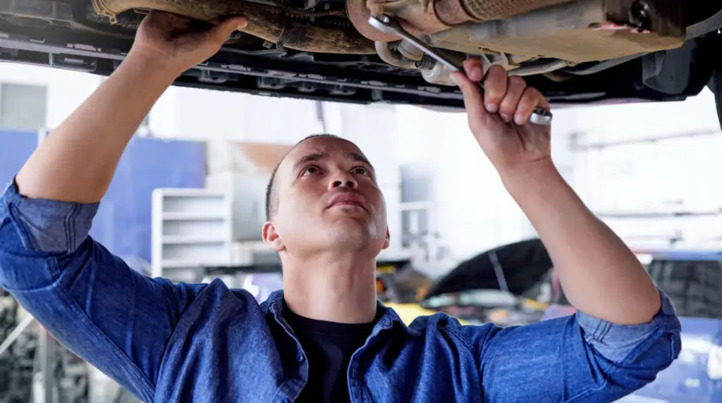 Mécanicien réparant système chauffage Renault Clio 3 sous capot moteur