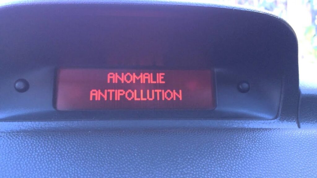 Voyant moteur orange allumé sur le tableau de bord d'une Peugeot 206, signalant une "Anomalie Antipollution".