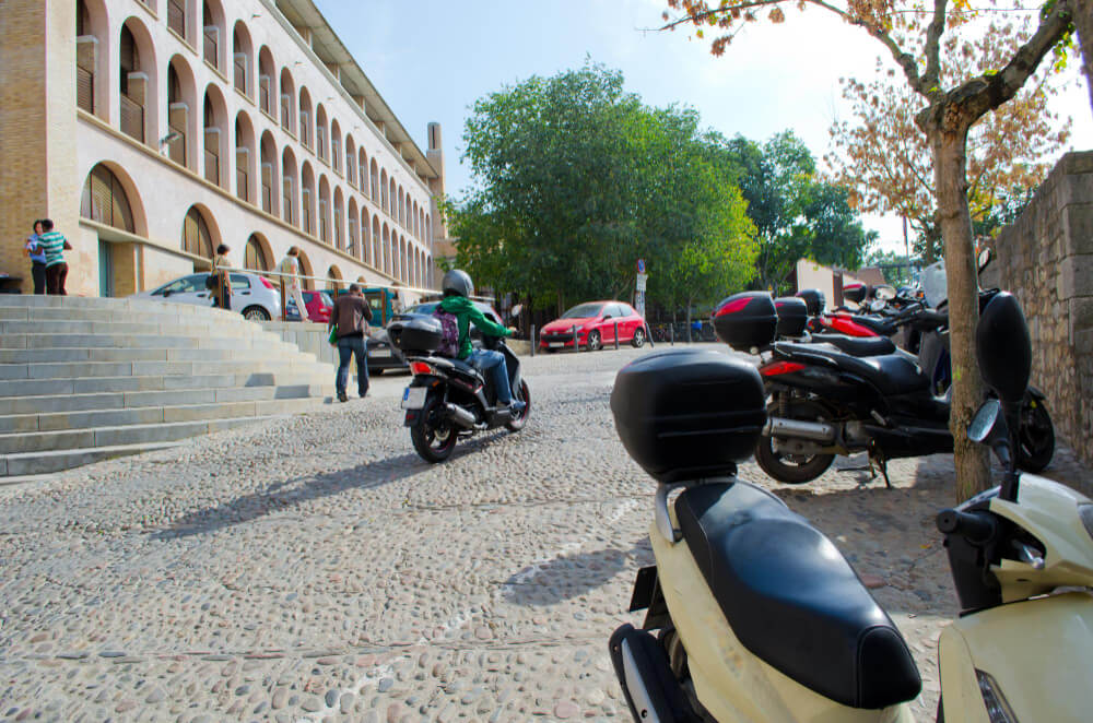 Scooter 125cc se faufilant dans la circulation urbaine.