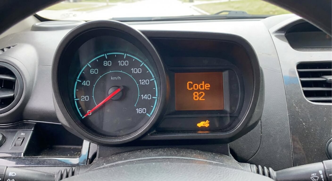Affichage du "Code 82" et du voyant jaune représentant une voiture avec une clé à molette sur l'écran LCD du compteur d'une Chevrolet Spark