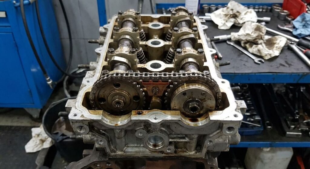 Vue ouverte de la culasse d'un moteur 1.6 HDi montrant la petite chaîne reliant les deux arbres à cames