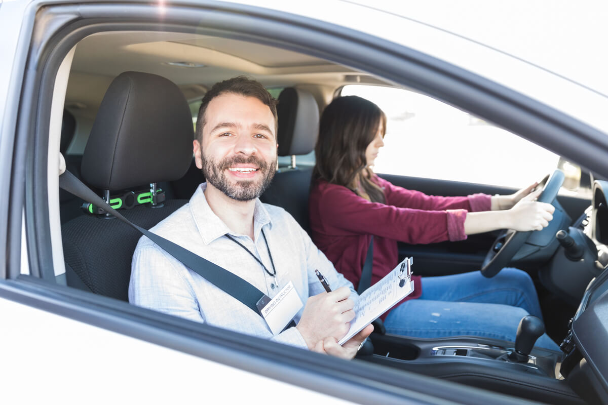 Un moniteur d'auto-école prodiguant des conseils à un jeune conducteur dans les rues de Toulon.