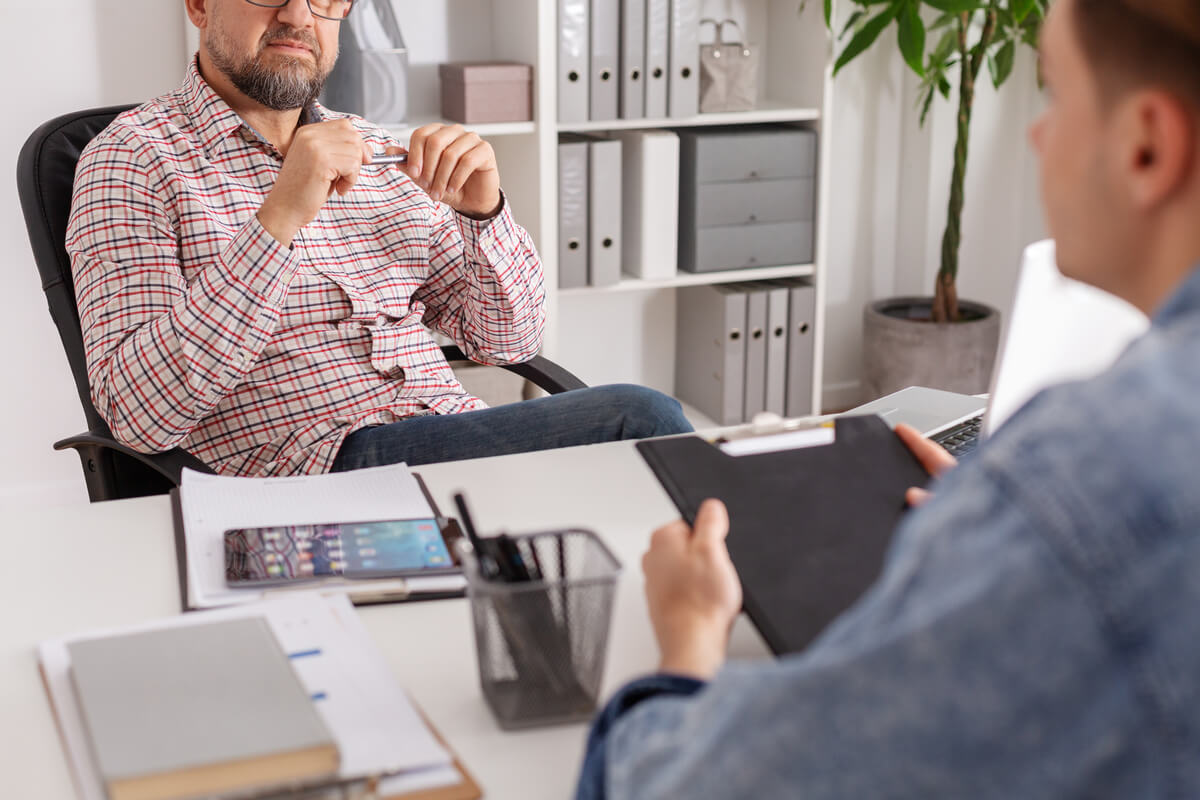 Un candidat en plein entretien individuel avec un psychologue agréé pour la récupération de son permis de conduire.