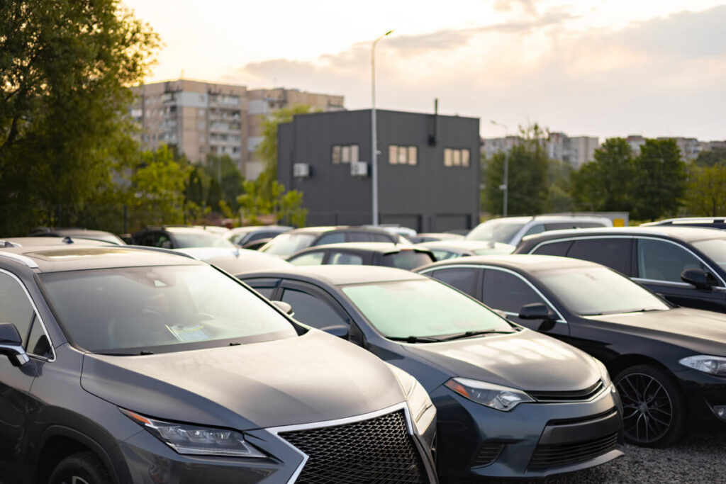 Alignement de véhicules d'occasion récents dans une concession allemande, offrant un large choix pour l'import.