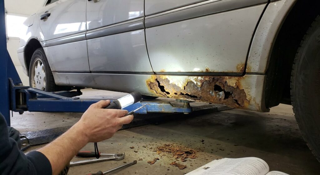 Inspection de la rouille perforante sur le bas de caisse d'une Mercedes W202
