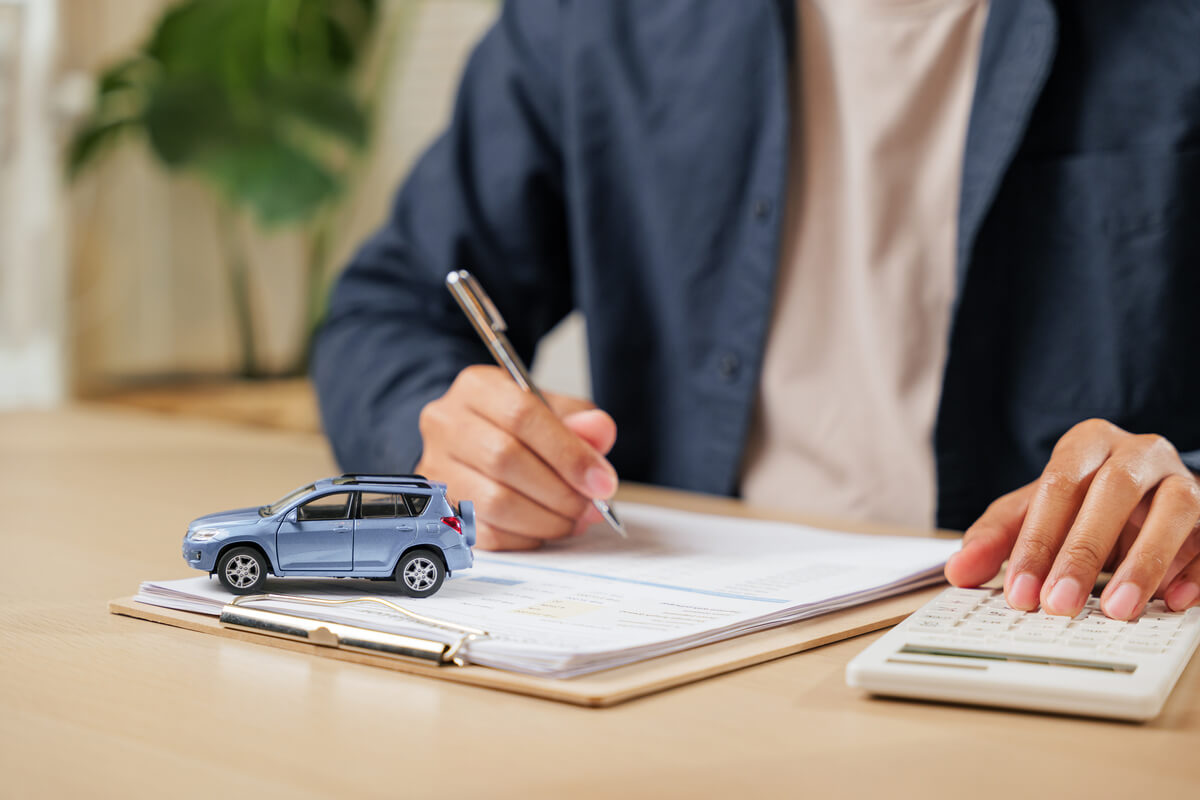 Une personne calculant la valeur et la cote de sa voiture sur un site d'estimation en ligne.