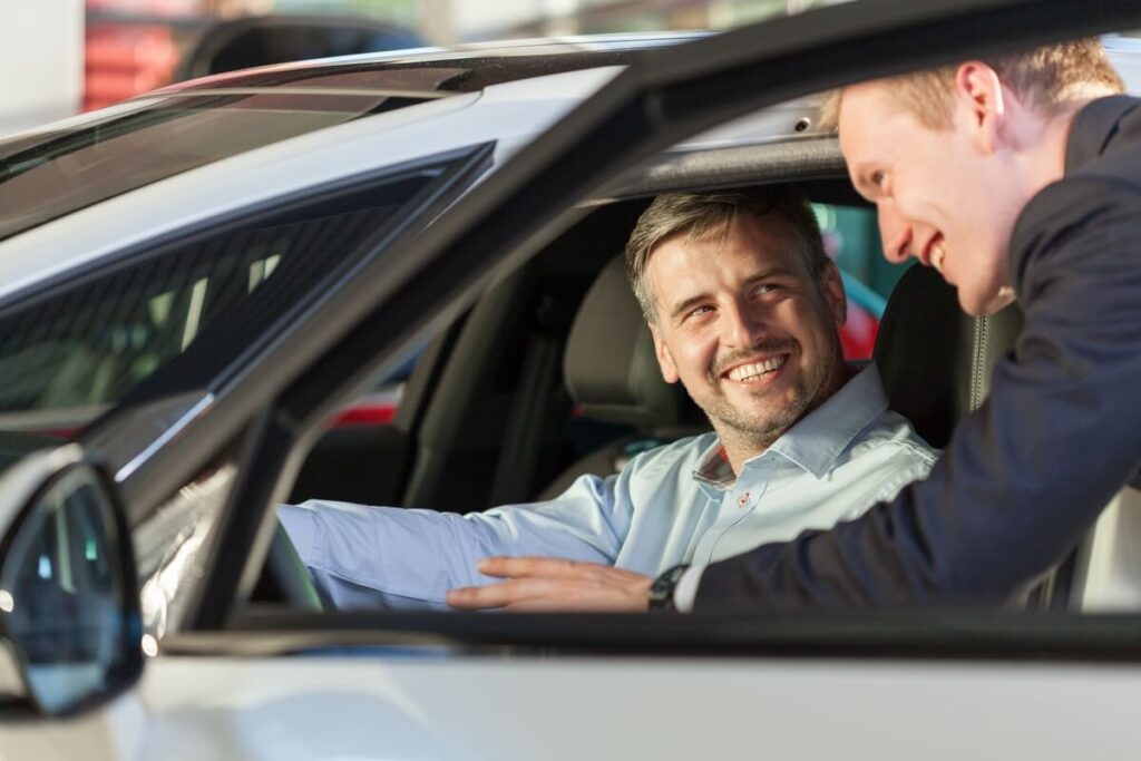 Le mandataire auto : l'alternative maline à la concession 3 Un client souriant finalisant l'achat de sa voiture avec une remise importante par rapport aux prix catalogue.