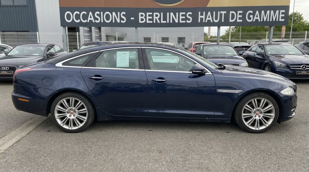Vue de profil d'une Jaguar XJ d'occasion, une berline haut de gamme en alliage d'aluminium.