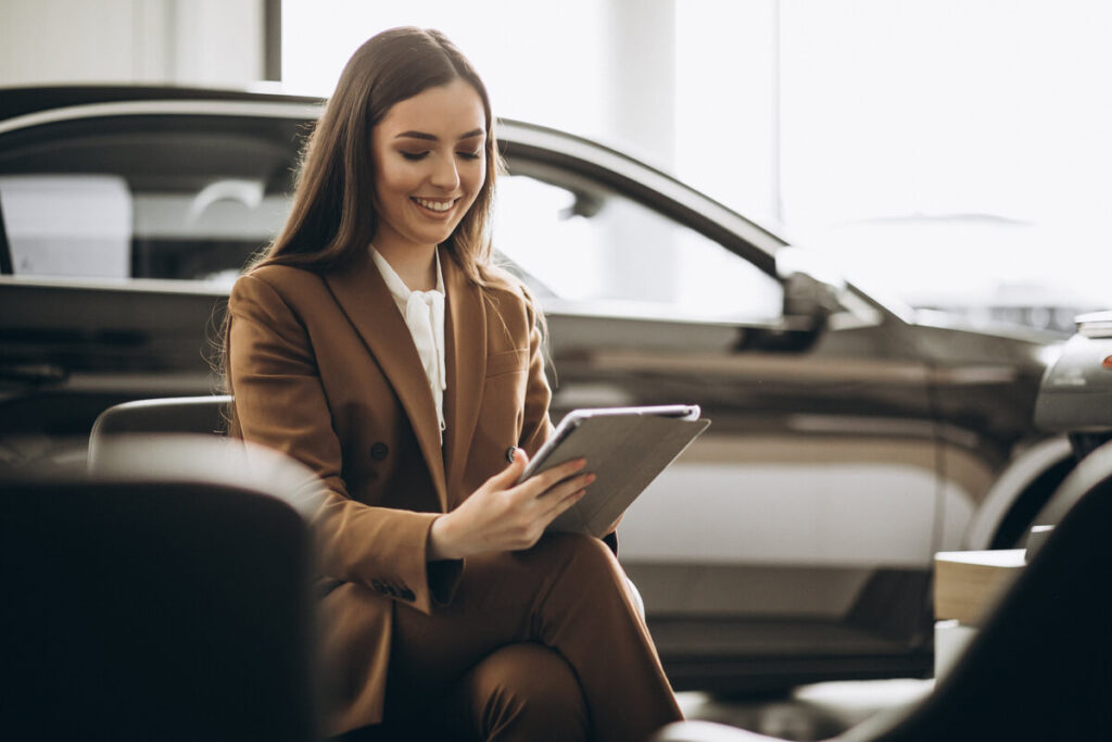Un propriétaire effectuant une estimation en ligne du prix de rachat de sa voiture sur une tablette.