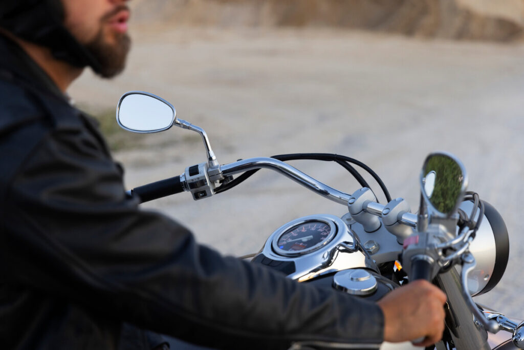 Position du robinet d'essence moto : comprendre ON, OFF, RES et PRI 4 Un motard arrêté sur le bas-côté de la route vérifiant le niveau de son réservoir.