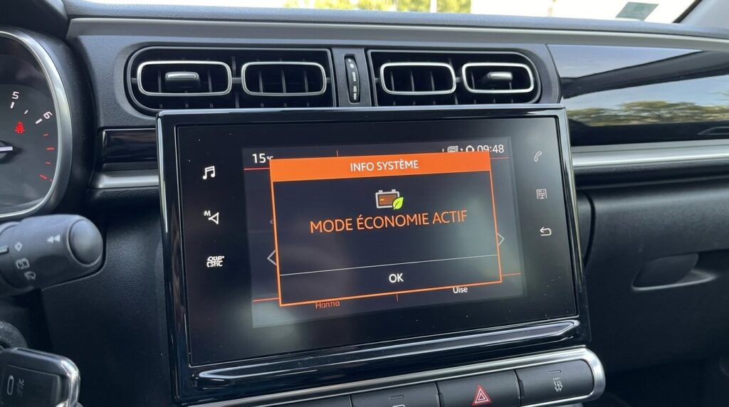 Mode économie actif sur Citroën C3 : pourquoi la voiture ne démarre pas ? 2 L'écran numérique central d'une Citroën C3 affichant le message de sécurité mode économie actif.