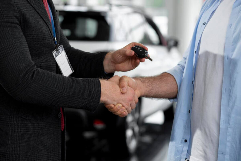 Une poignée de main entre un particulier et un acheteur professionnel scellant le rachat rapide de la voiture.