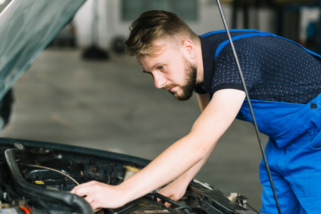 Tout savoir sur votre boite de vitesse automatique 4 Un mécanicien utilisant une station de vidange par rinçage pour remplacer l'huile usagée d'une transmission automatique.
