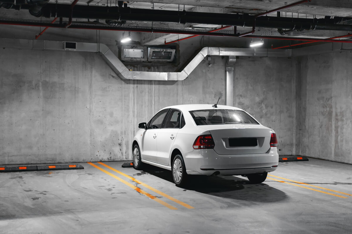 Une voiture restée immobile longtemps sous une housse dans un garage.