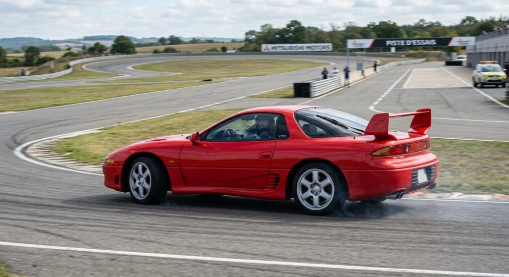 Mitsubishi 3000GT VR4 rouge affichant son aileron actif déployé sur piste d'essai.