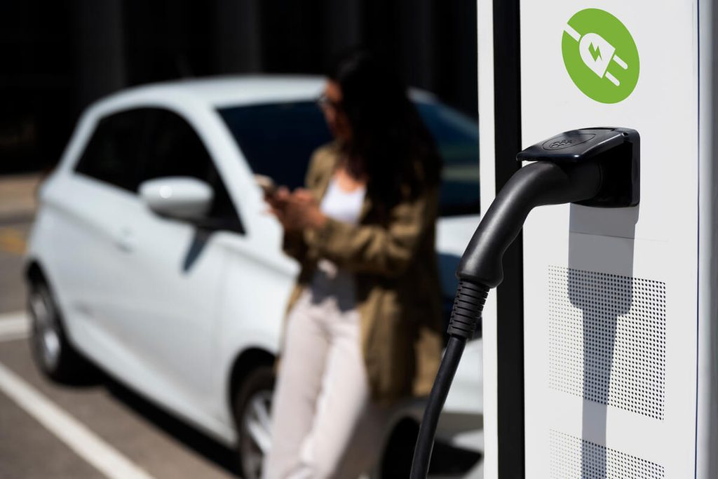 Voiture électrique branchée sur une borne de recharge rapide sur une aire d'autoroute.