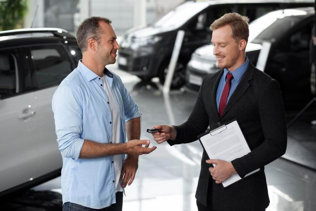 Vendeur et acheteur signant le certificat de cession Cerfa pour la vente d'une voiture d'occasion.
