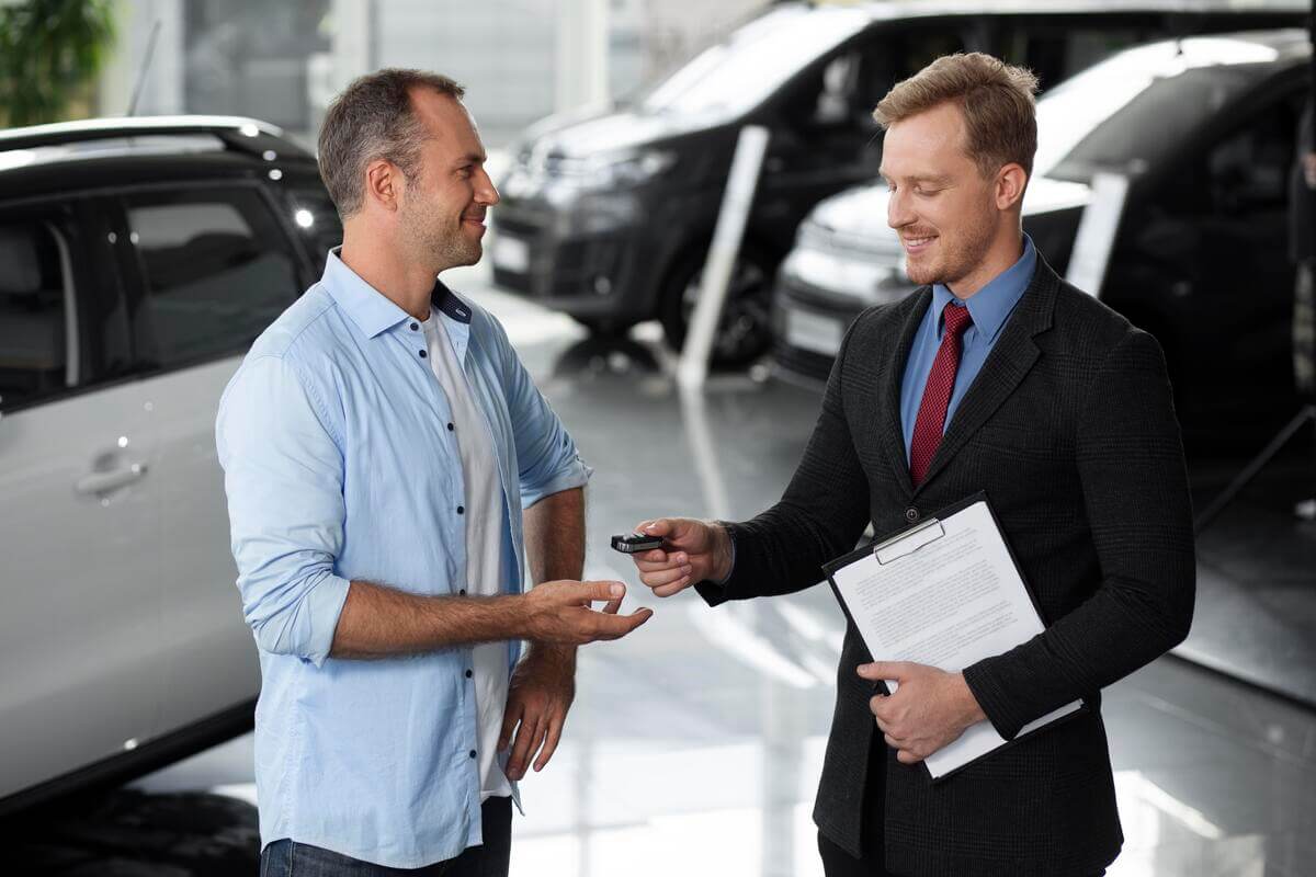 Vendeur et acheteur signant le certificat de cession Cerfa pour la vente d'une voiture d'occasion.